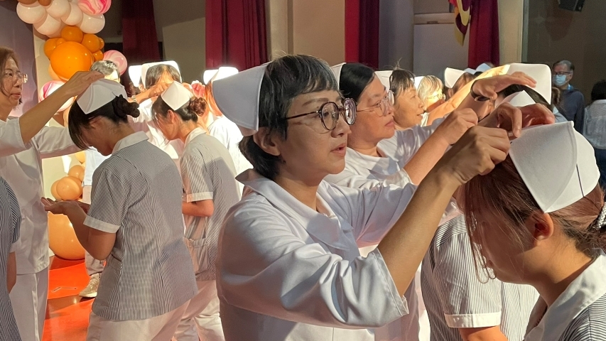 中華醫大護理系115年加冠典禮，護理專業老師為加冠學生戴上護師帽。